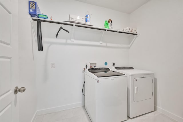 washroom featuring light tile patterned flooring and washing machine and clothes dryer