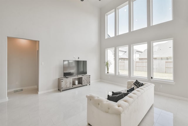 tiled living room with a towering ceiling