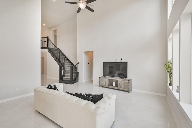 living room featuring a towering ceiling and ceiling fan