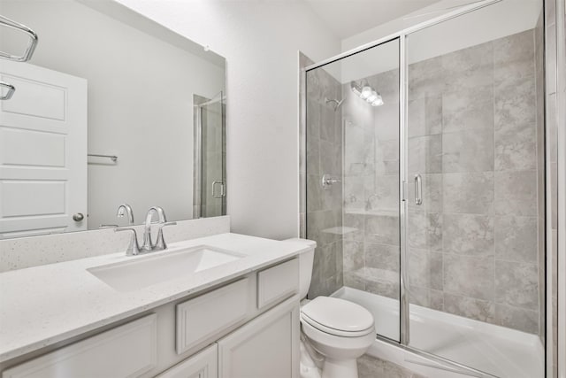 bathroom featuring vanity, toilet, and a shower with shower door