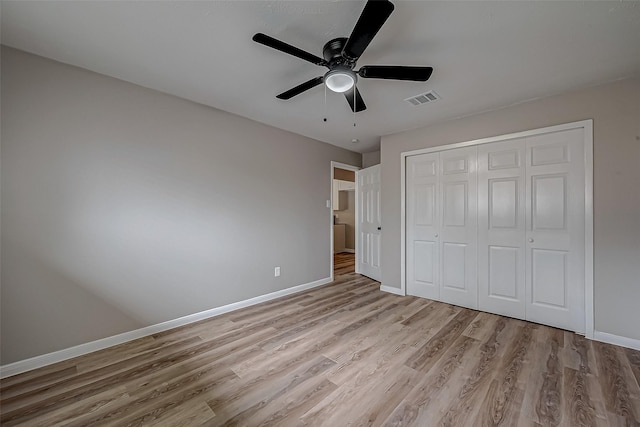 unfurnished bedroom with light hardwood / wood-style flooring, a closet, and ceiling fan