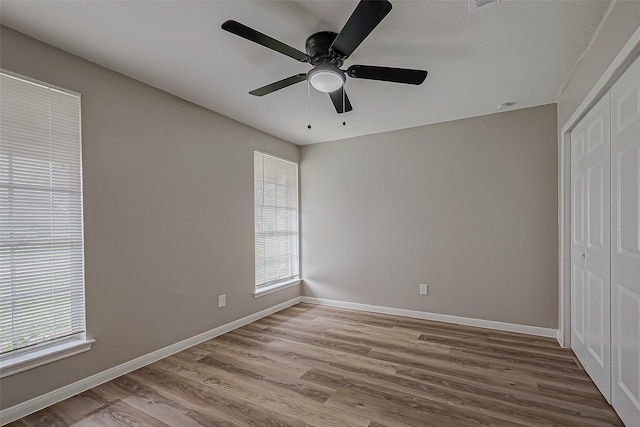 unfurnished bedroom with light hardwood / wood-style flooring, ceiling fan, and a closet