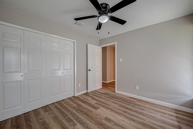 unfurnished bedroom with light hardwood / wood-style floors, a closet, and ceiling fan