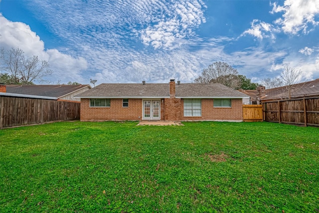 rear view of property with french doors and a yard