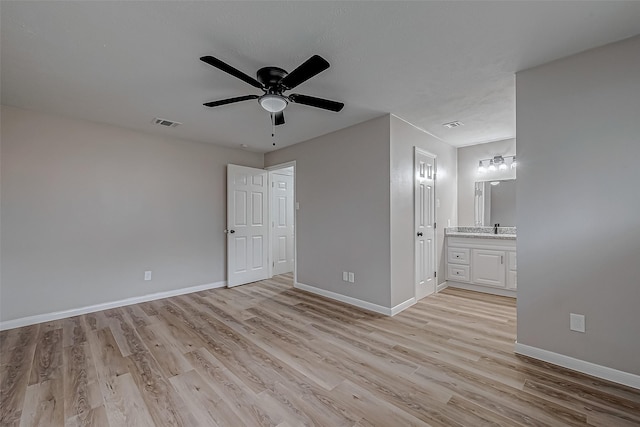 unfurnished bedroom featuring ceiling fan, ensuite bath, sink, and light hardwood / wood-style flooring