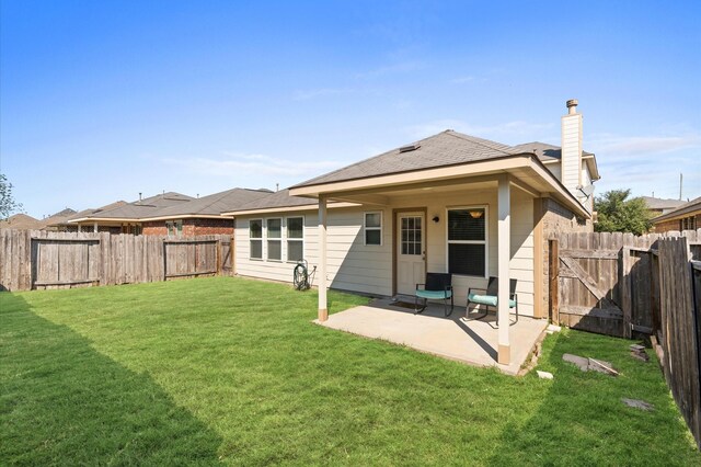 back of property featuring a yard and a patio