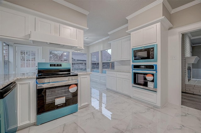 kitchen with white cabinetry, ornamental molding, appliances with stainless steel finishes, and light stone countertops