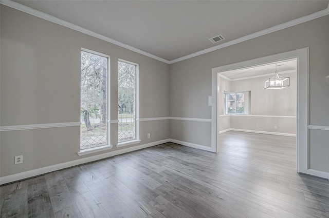 unfurnished room featuring ornamental molding, plenty of natural light, and light hardwood / wood-style flooring