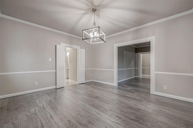 unfurnished dining area with wood-type flooring, a textured ceiling, and crown molding