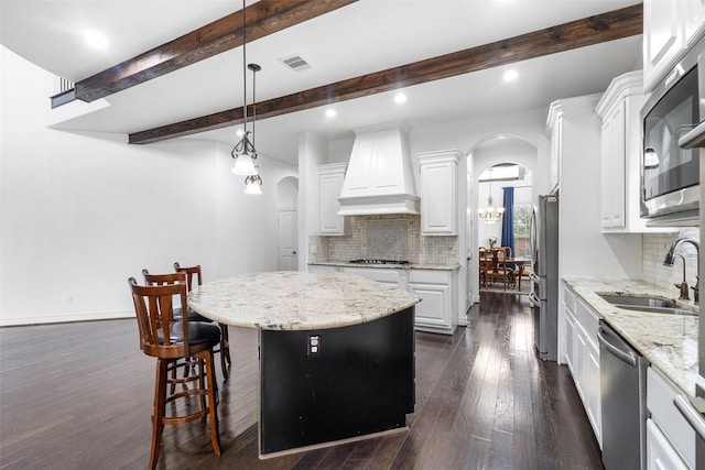 18007 Stari Most Ln, Houston, TX 77044 - kitchen with custom range hood, stainless steel appliances, a sink, arched walkways, and beamed ceiling