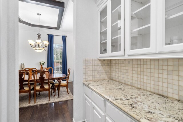 18007 Stari Most Ln, Houston, TX 77044 - bar with dark wood finished floors, a chandelier, decorative backsplash, crown molding, and pendant lighting