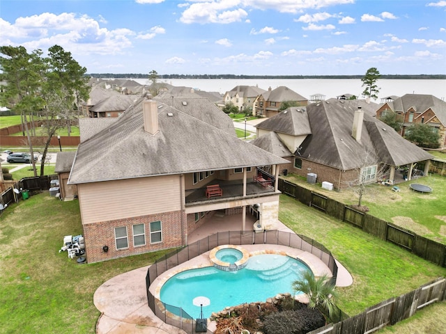 18007 Stari Most Ln, Houston, TX 77044 - back of house featuring brick siding, a residential view, a pool with connected hot tub, a water view, and a chimney