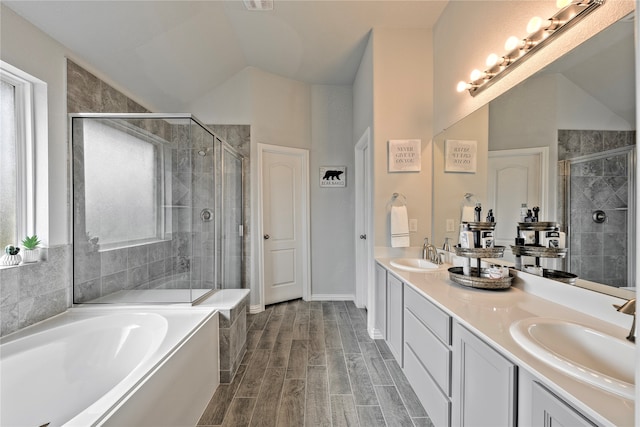 full bath featuring lofted ceiling, a stall shower, a sink, and wood tiled floor