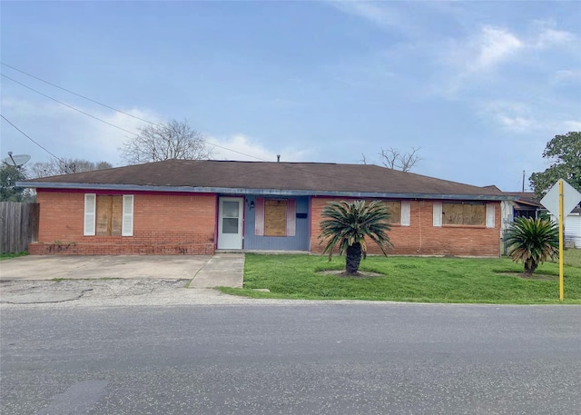 ranch-style house featuring brick siding, fence, and a front lawn