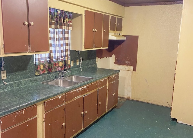 kitchen with dishwashing machine, dark countertops, a sink, and under cabinet range hood