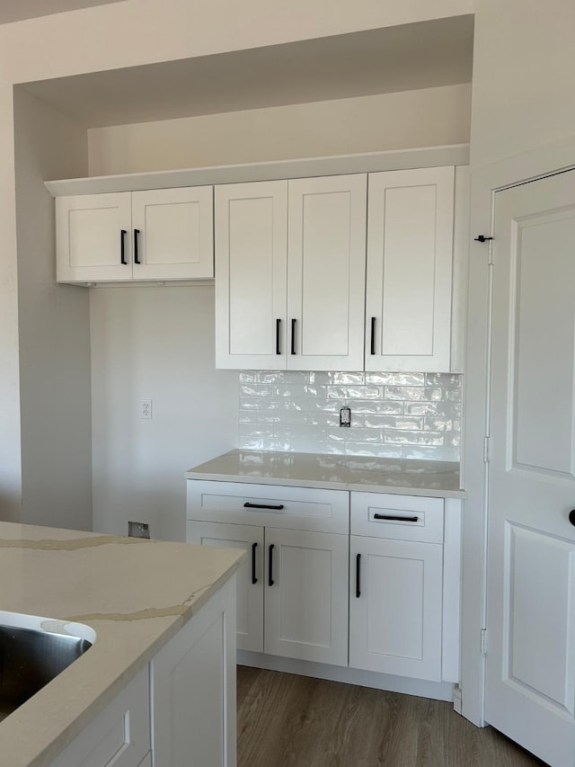 kitchen featuring white cabinetry, light stone counters, tasteful backsplash, and dark hardwood / wood-style floors