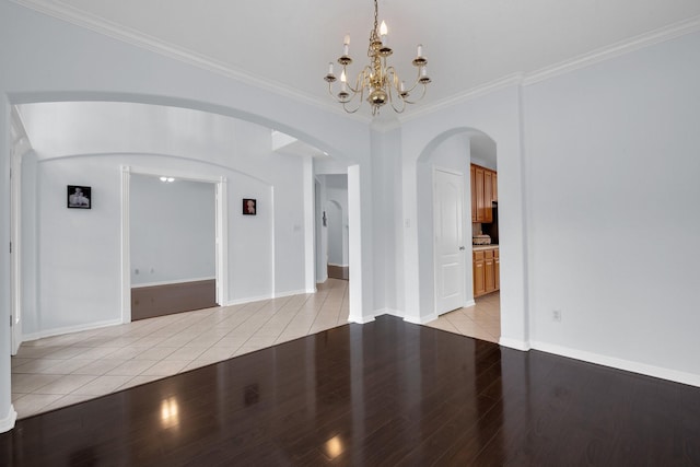 unfurnished room with ornamental molding, an inviting chandelier, and light wood-type flooring