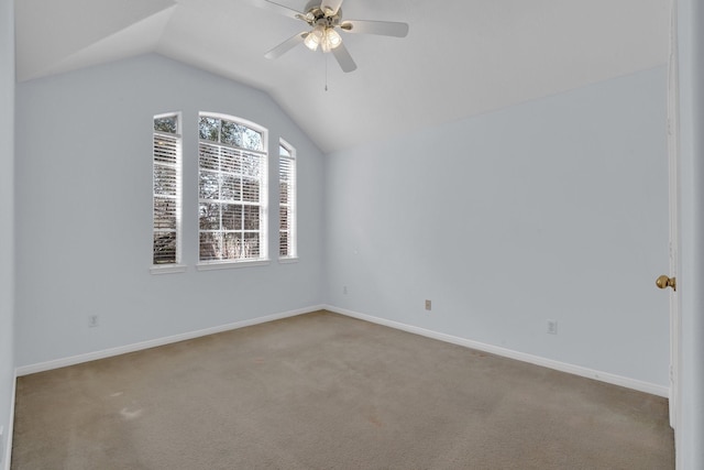 carpeted spare room featuring lofted ceiling and ceiling fan