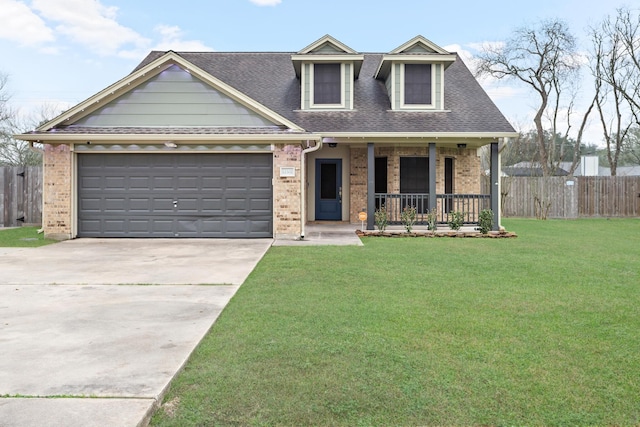 view of front of home featuring a garage, covered porch, and a front lawn