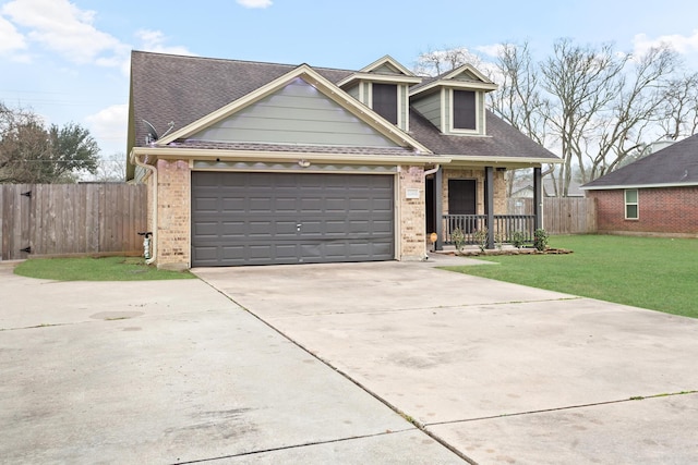 view of front of home with a garage, a front lawn, and covered porch