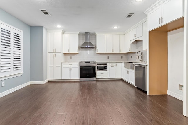 kitchen with white cabinetry, dark hardwood / wood-style floors, stainless steel appliances, decorative backsplash, and wall chimney range hood