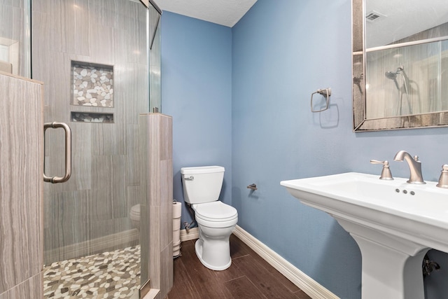 bathroom featuring an enclosed shower, sink, and toilet