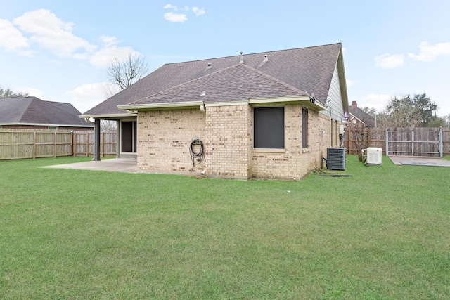 back of house with central air condition unit, a patio area, and a lawn