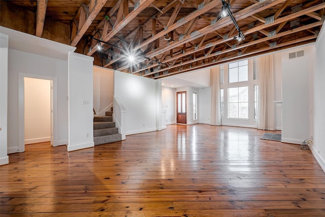 interior space featuring stairs, wood finished floors, visible vents, and baseboards