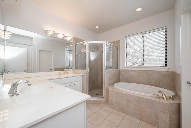 bathroom featuring a garden tub, a sink, a shower stall, tile patterned floors, and double vanity