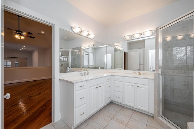 full bath featuring double vanity, tile patterned flooring, a shower stall, and a sink