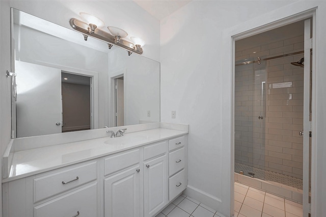 bathroom with a stall shower, tile patterned flooring, baseboards, and vanity