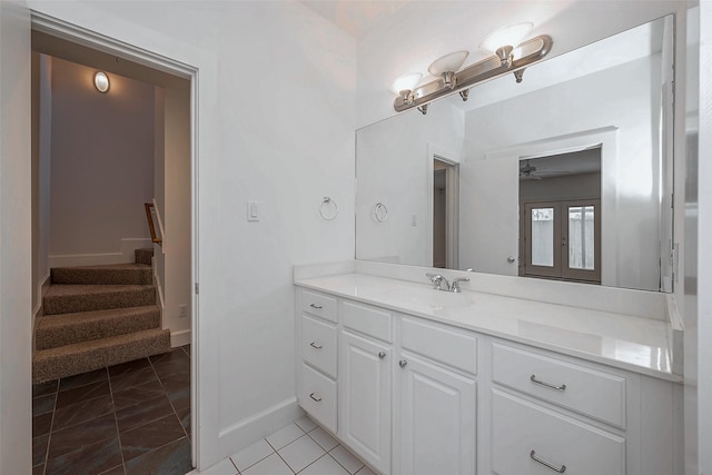 bathroom featuring a ceiling fan, tile patterned flooring, vanity, and baseboards