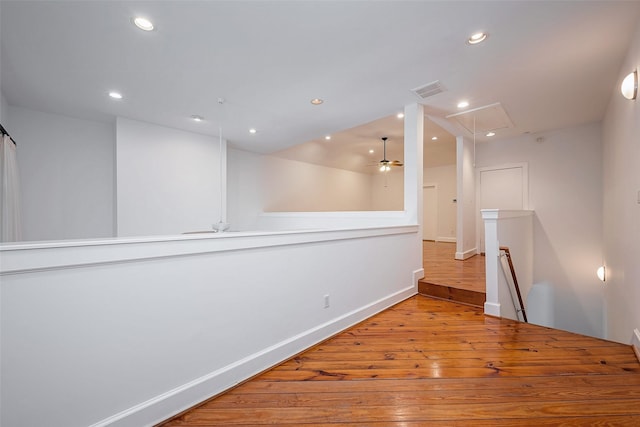 unfurnished room featuring attic access, visible vents, baseboards, light wood-type flooring, and recessed lighting