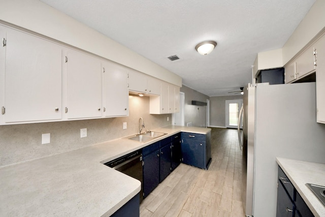 kitchen with blue cabinets, sink, white cabinetry, fridge, and black dishwasher