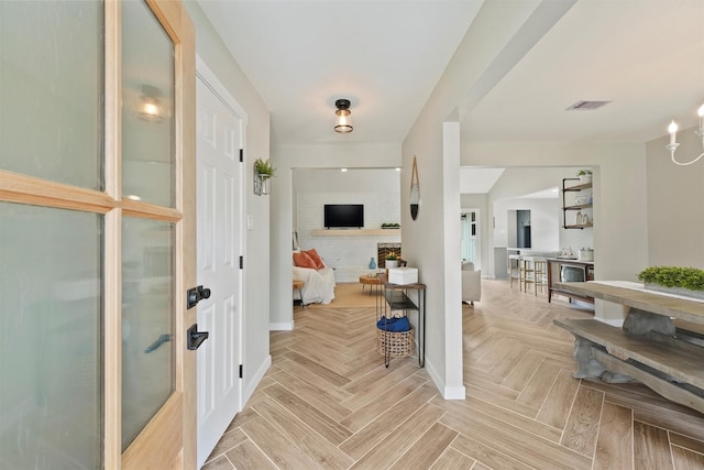 foyer featuring light parquet flooring and a fireplace