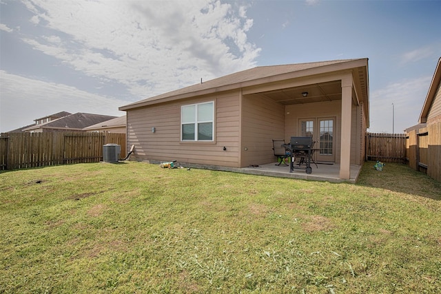 rear view of house featuring a patio, a yard, and central AC