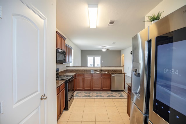 kitchen with sink, ceiling fan, black appliances, light tile patterned flooring, and kitchen peninsula