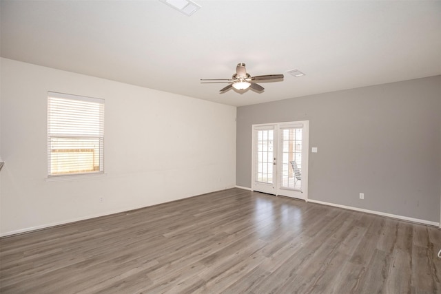 empty room with french doors, ceiling fan, and wood-type flooring