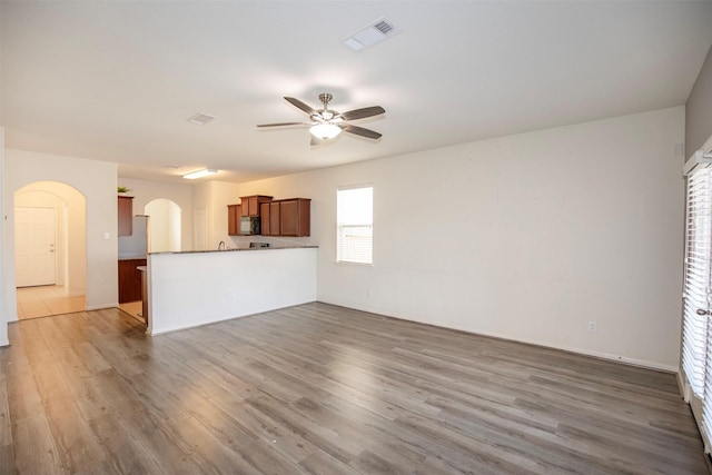 unfurnished living room featuring hardwood / wood-style floors and ceiling fan