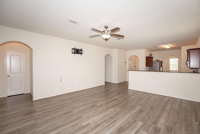 unfurnished living room with ceiling fan and wood-type flooring