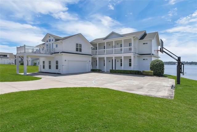 view of front of house with a garage, a water view, basketball court, and a front lawn