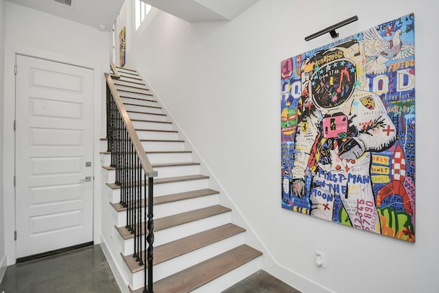 staircase with concrete flooring