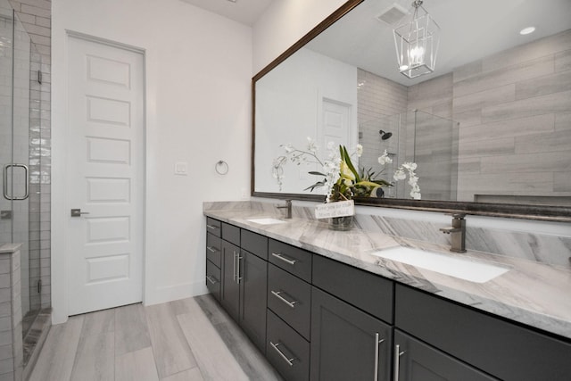 bathroom featuring a shower with door, vanity, and wood-type flooring