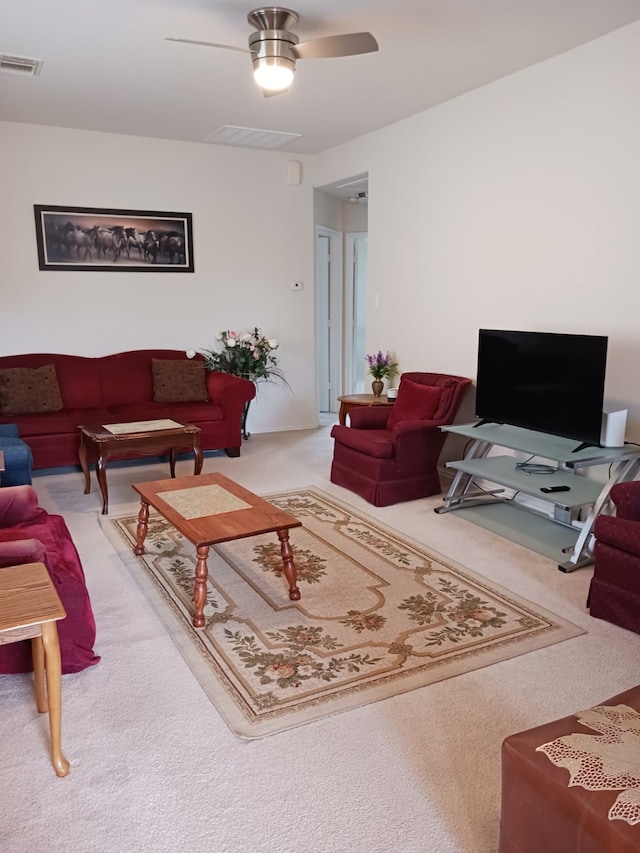 carpeted living room with ceiling fan