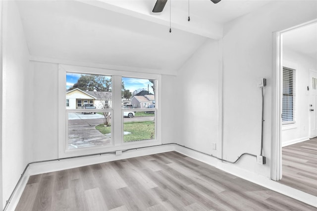 interior space featuring ceiling fan, light wood-type flooring, and vaulted ceiling with beams