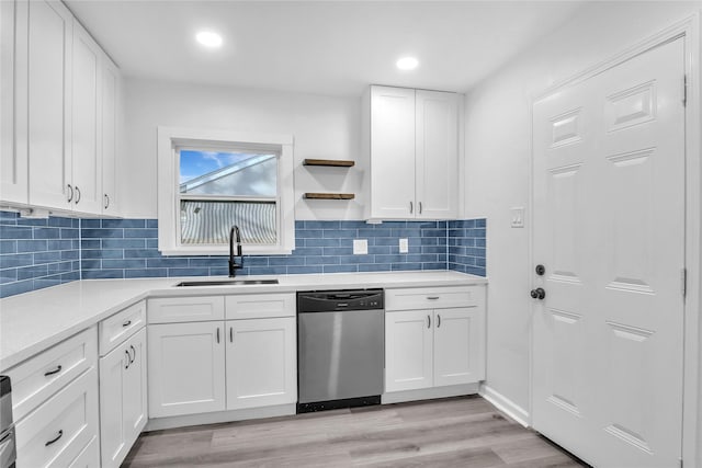 kitchen featuring sink, tasteful backsplash, light hardwood / wood-style flooring, dishwasher, and white cabinets