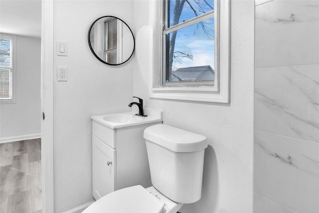 bathroom with wood-type flooring, toilet, and vanity