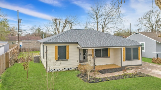 view of front of home with central AC and a front lawn