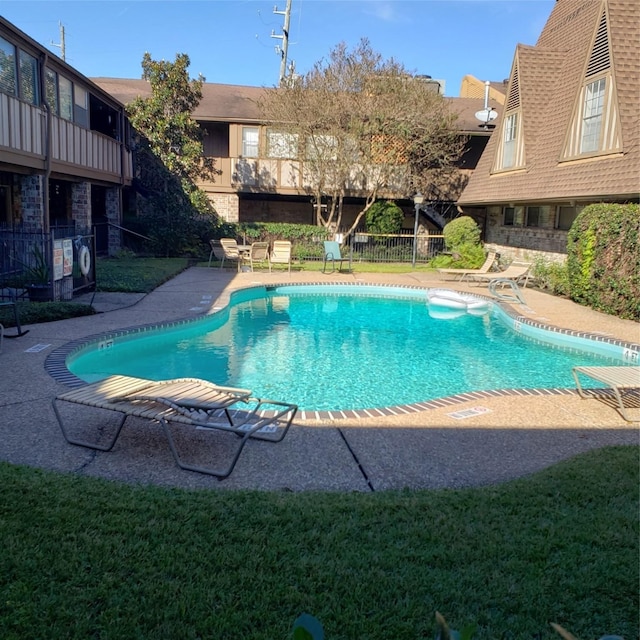 view of swimming pool with a patio and a lawn