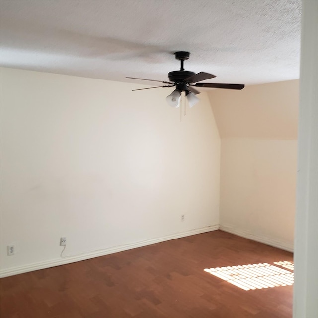 unfurnished room featuring lofted ceiling, ceiling fan, wood-type flooring, and a textured ceiling